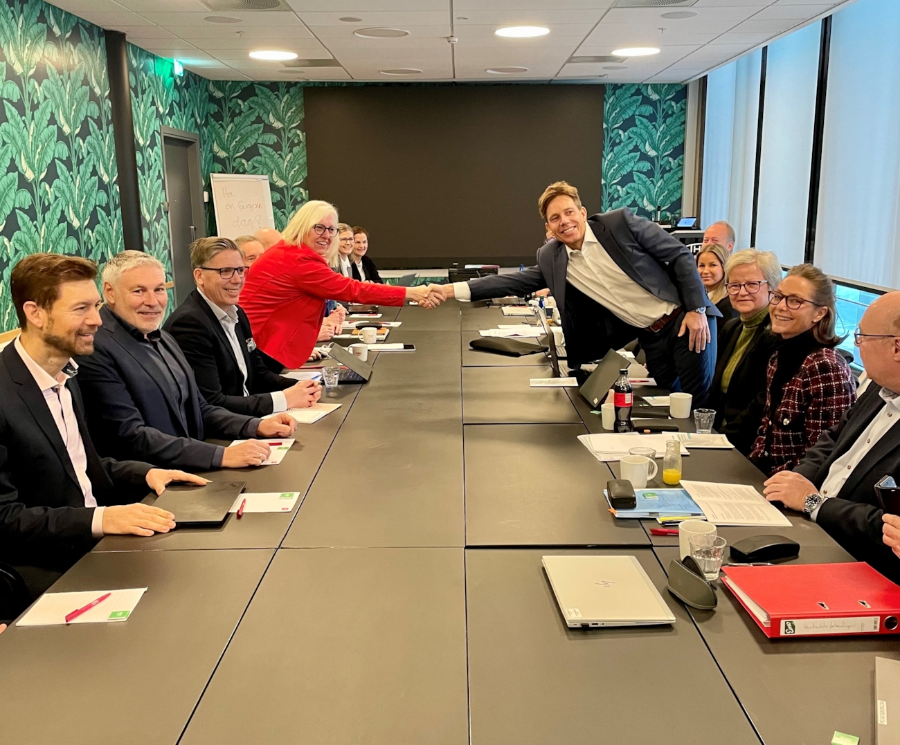 Finansforbundets forbundsleder Vigdis Mathisen og Finans Norges forhandlingsdirektør Thomas Keiserud hilser på hverandre over bordet. Foto.