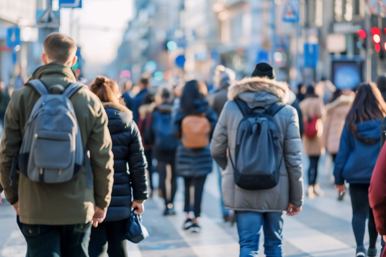 En folkemengde i en bygate. Alle med ryggen til. Vinter.