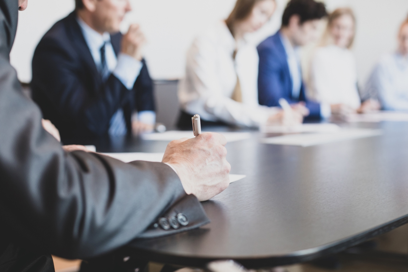 Personer rundt et møtebord. Foto.