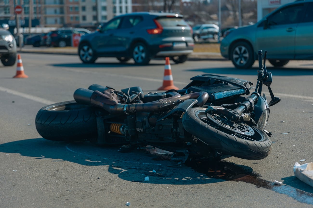 Skadet motorsykkel ligger i veibanen.