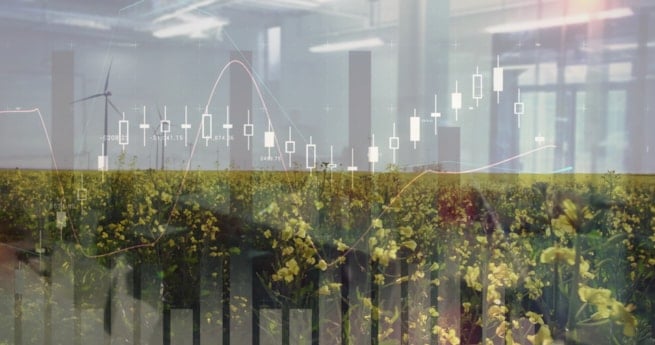 Flyfoto av vindmøller og jordbrukslandskap med grafikk som illustrerer finansielle data og investeringer. Foto.